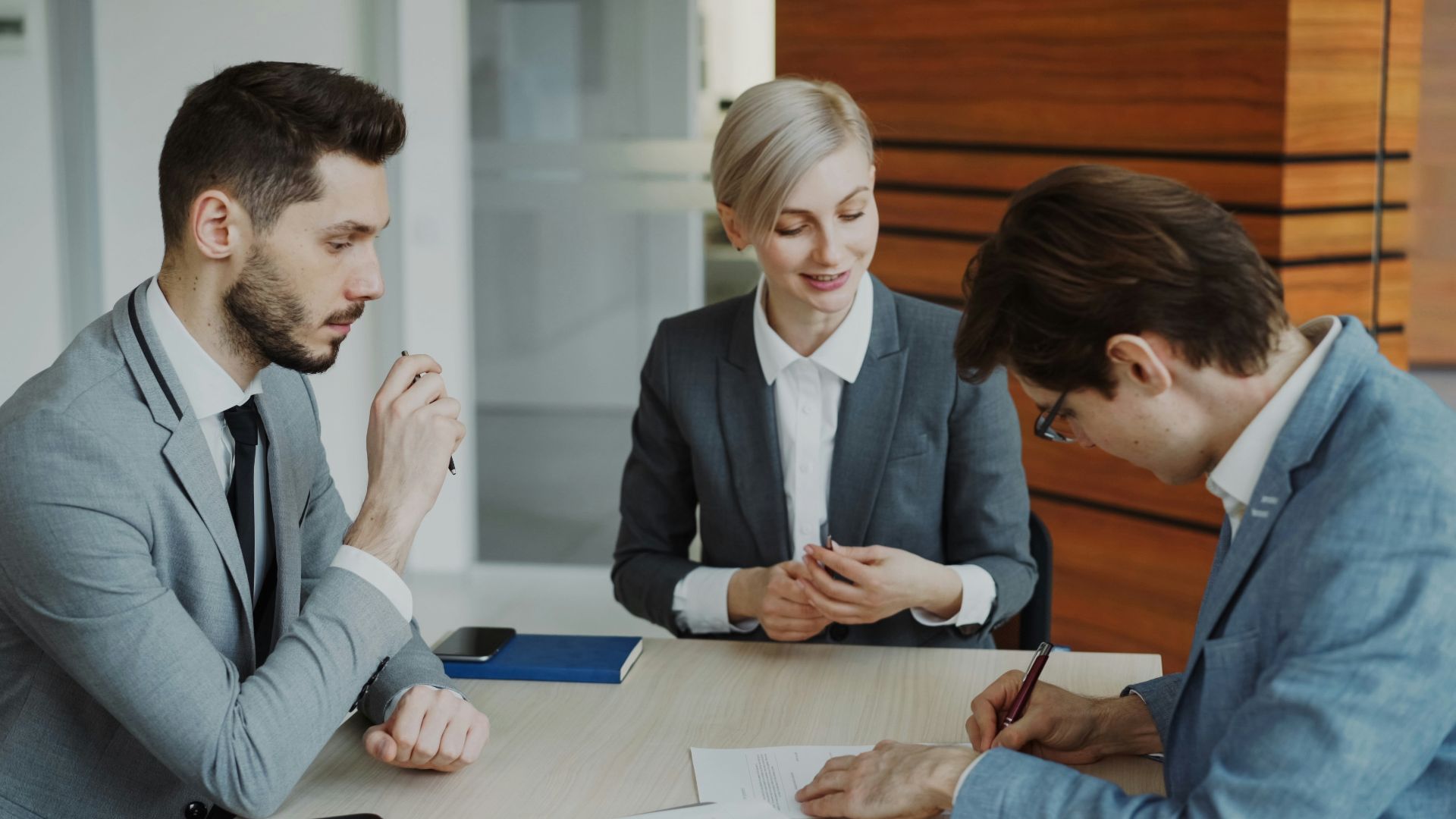 Business people signing a contract at a table