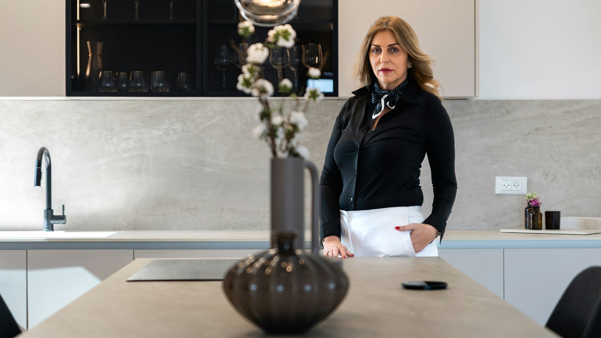 Woman standing in a modern kitchen with island