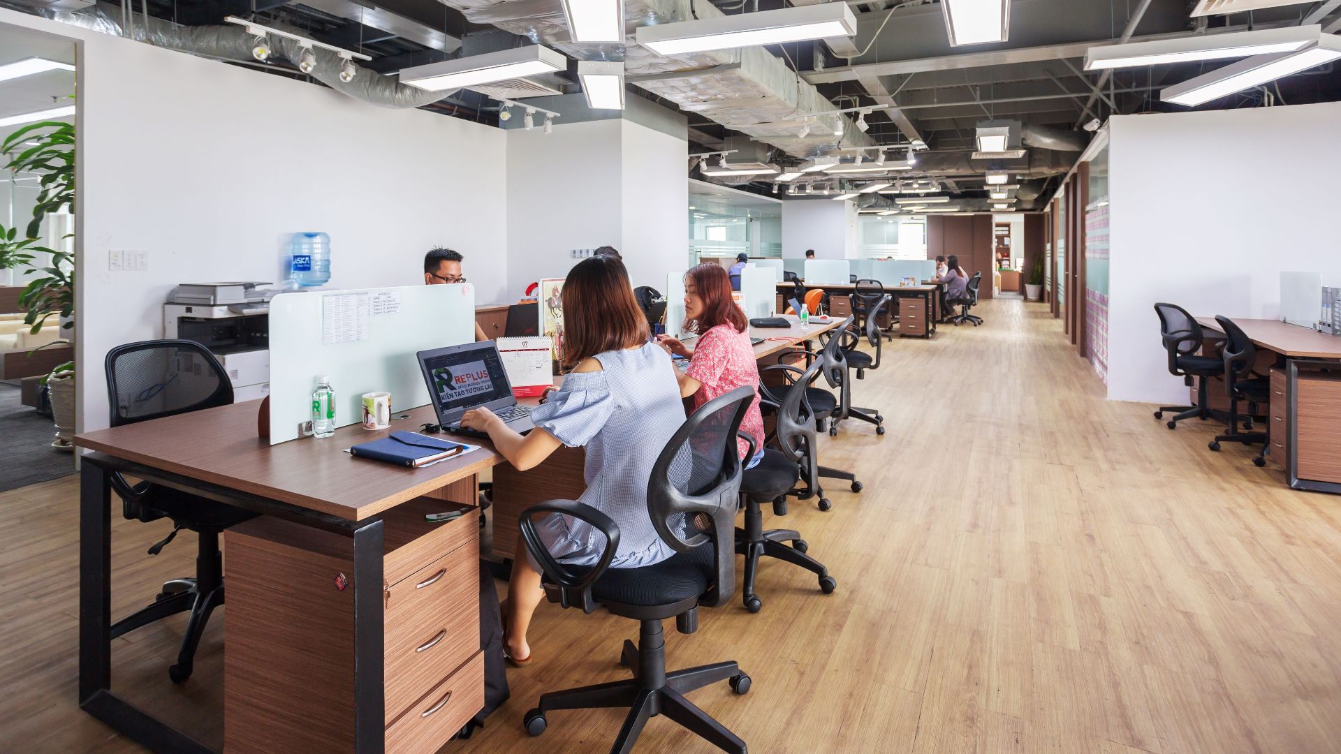 Spacious modern office in Vietnam with employees collaborating at desks.