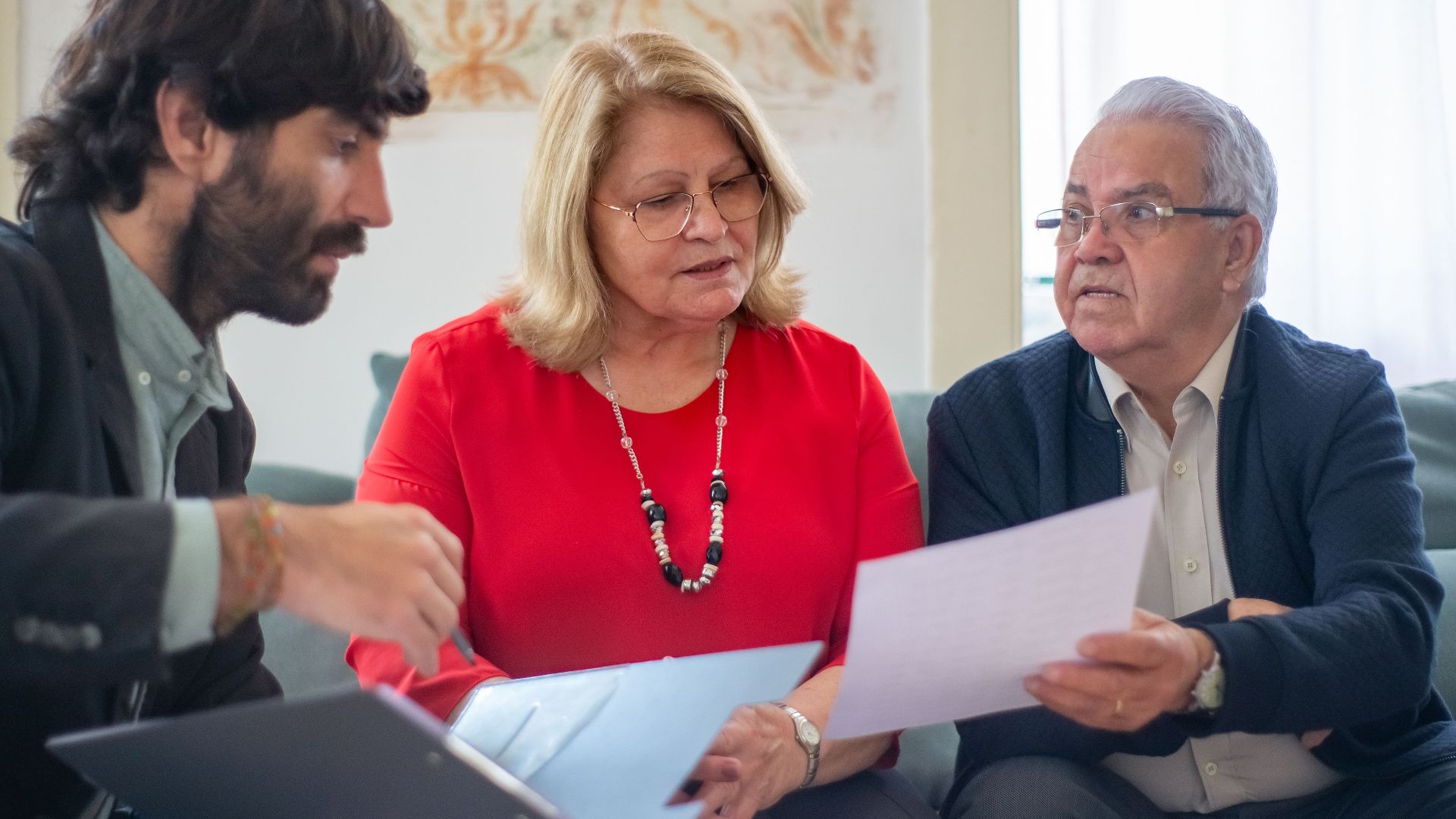 Senior couple consulting with a professional advisor, discussing documents indoors.