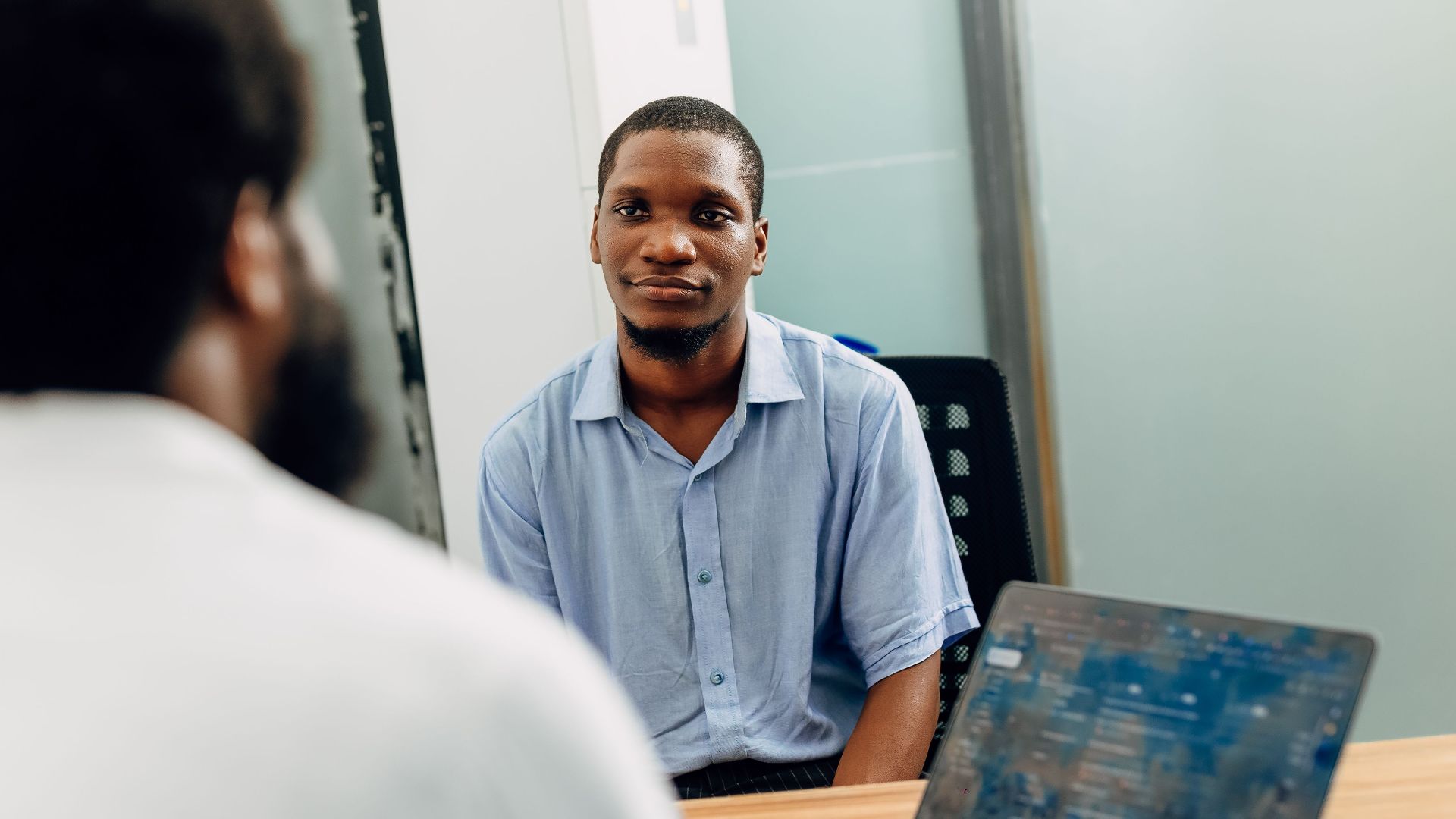 A business meeting in a modern office in Lagos, Nigeria featuring two professionals engaged in a discussion.