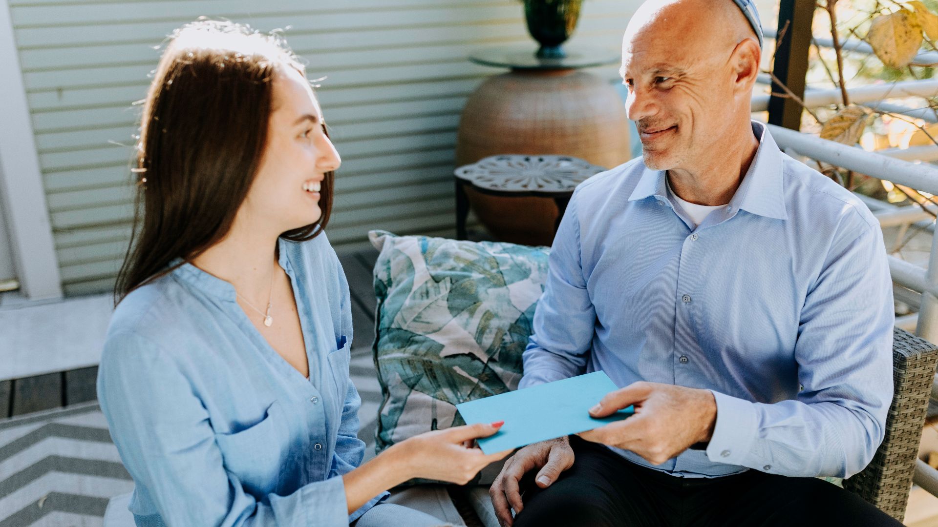 A father and daughter exchange a card in a warm and happy setting, symbolizing love and togetherness.