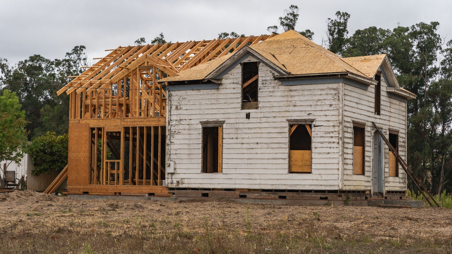 Image of an old house under renovation with new wooden frame structure.