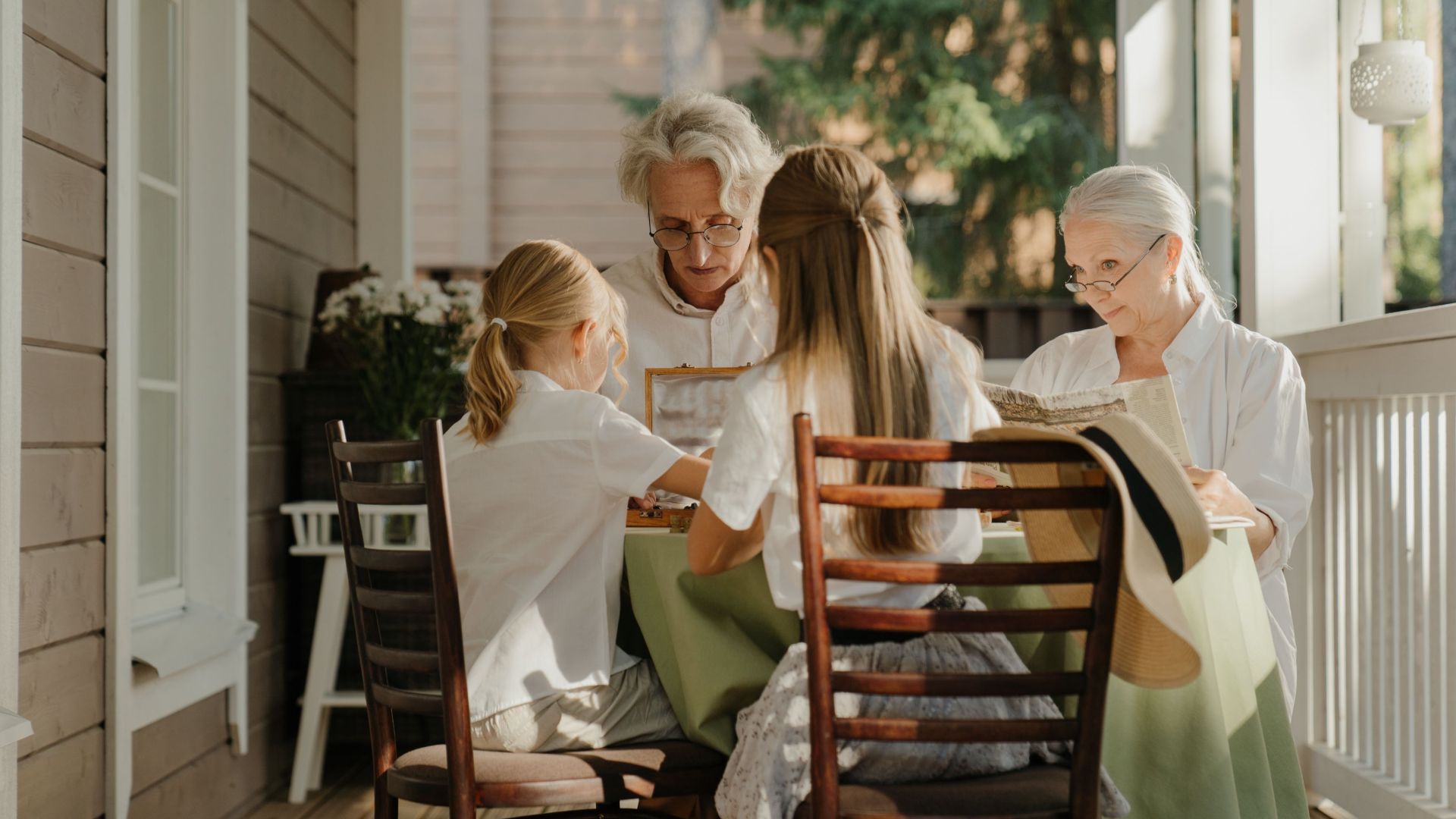 Multi-generational family sharing a moment on a sunlit veranda, capturing togetherness.