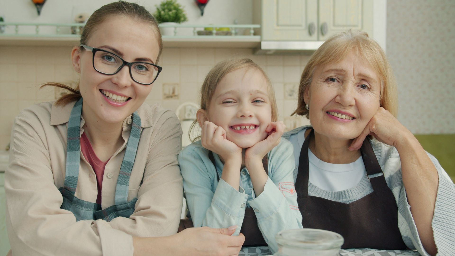 Happy family of three generations smiling together in kitchen.