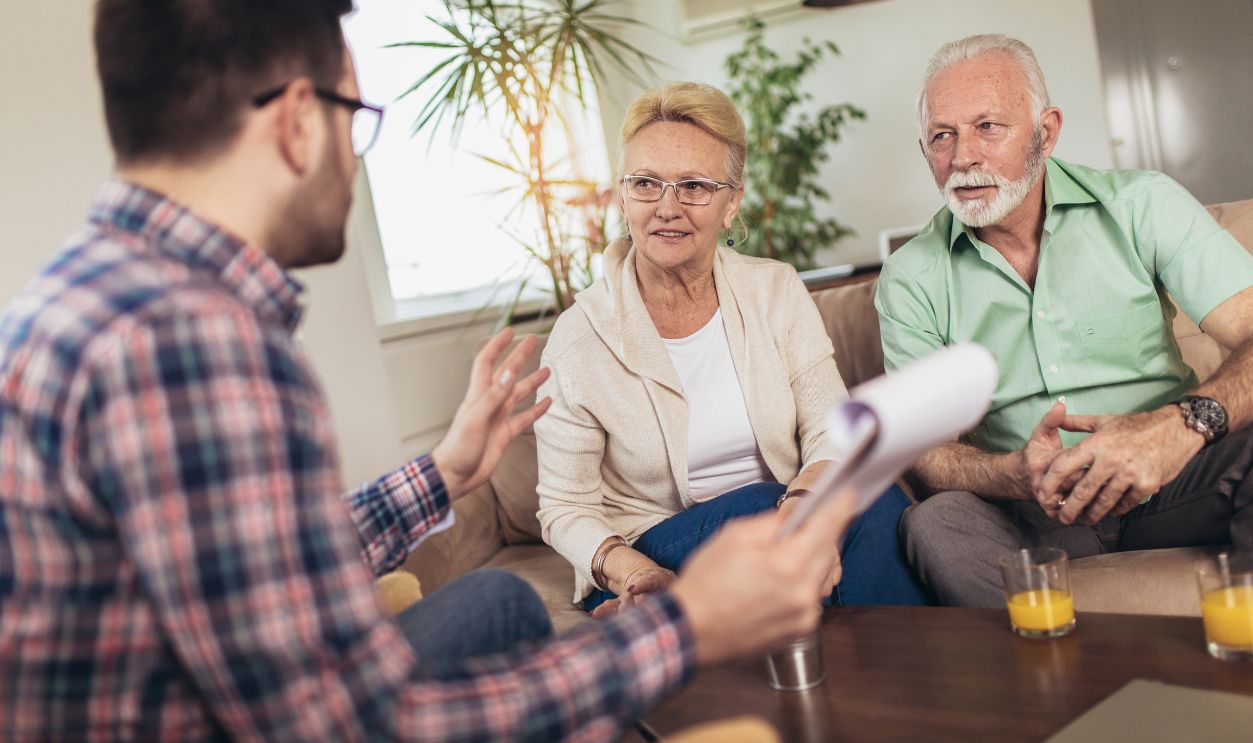 Positive aged couple consulting with insurance agent