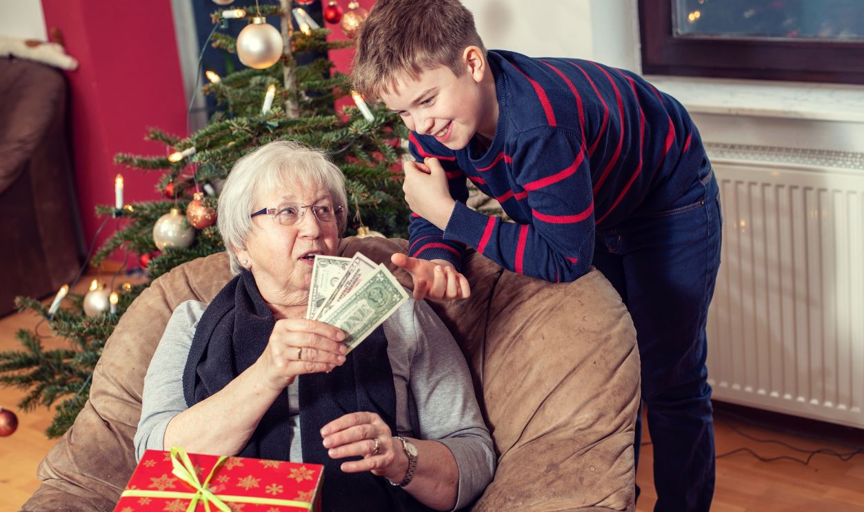 female senior has a money- gift for her grandson