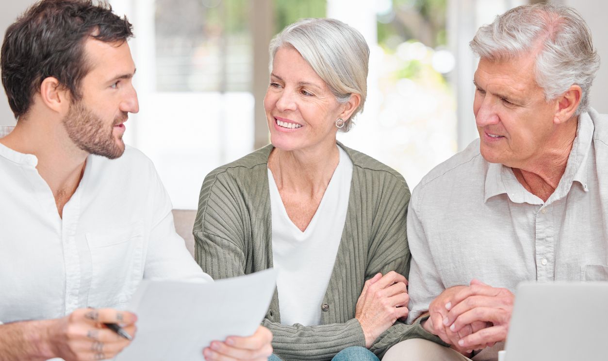 Financial advisor, laptop and old couple with documents, house and conversation in lounge. Consultant, senior man and elderly woman with pc, paperwork and planning for future, budget and retirement