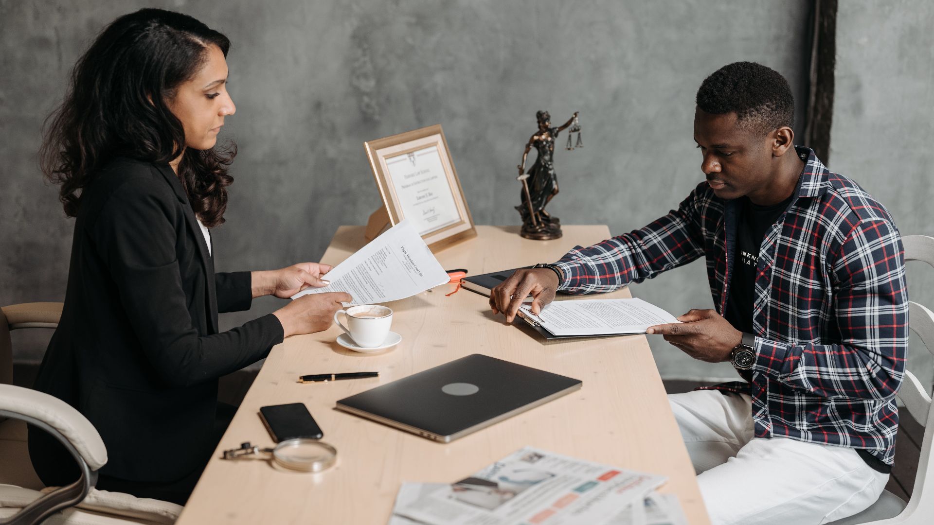 Business professionals discussing documents in a modern office setting.