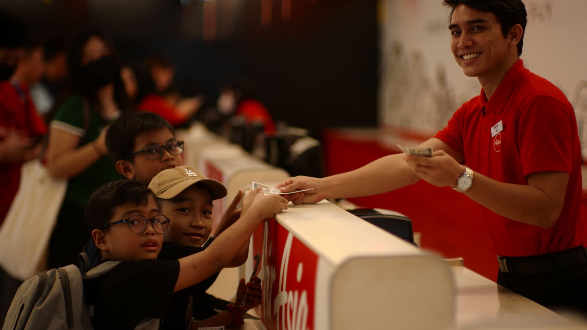 Kids purchasing tickets at a service counter in Kuala Lumpur, Malaysia.