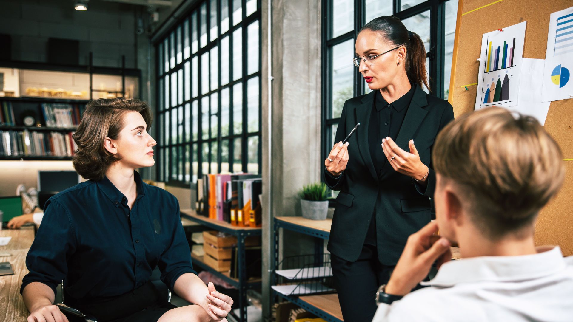 Three colleagues engage in a vibrant business meeting in a modern office setting.