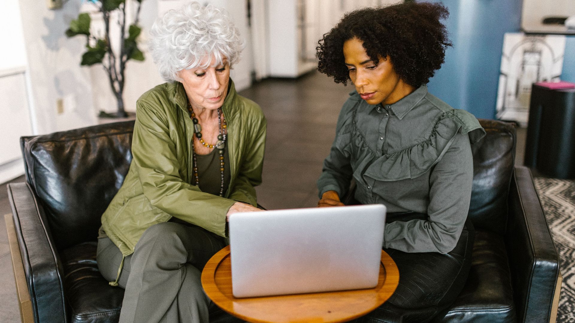 Two women discussing business plans on a laptop in a modern office.