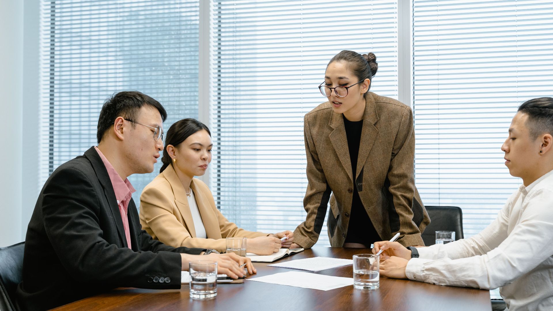 Business team engaged in a thoughtful meeting around a table in a modern conference room.