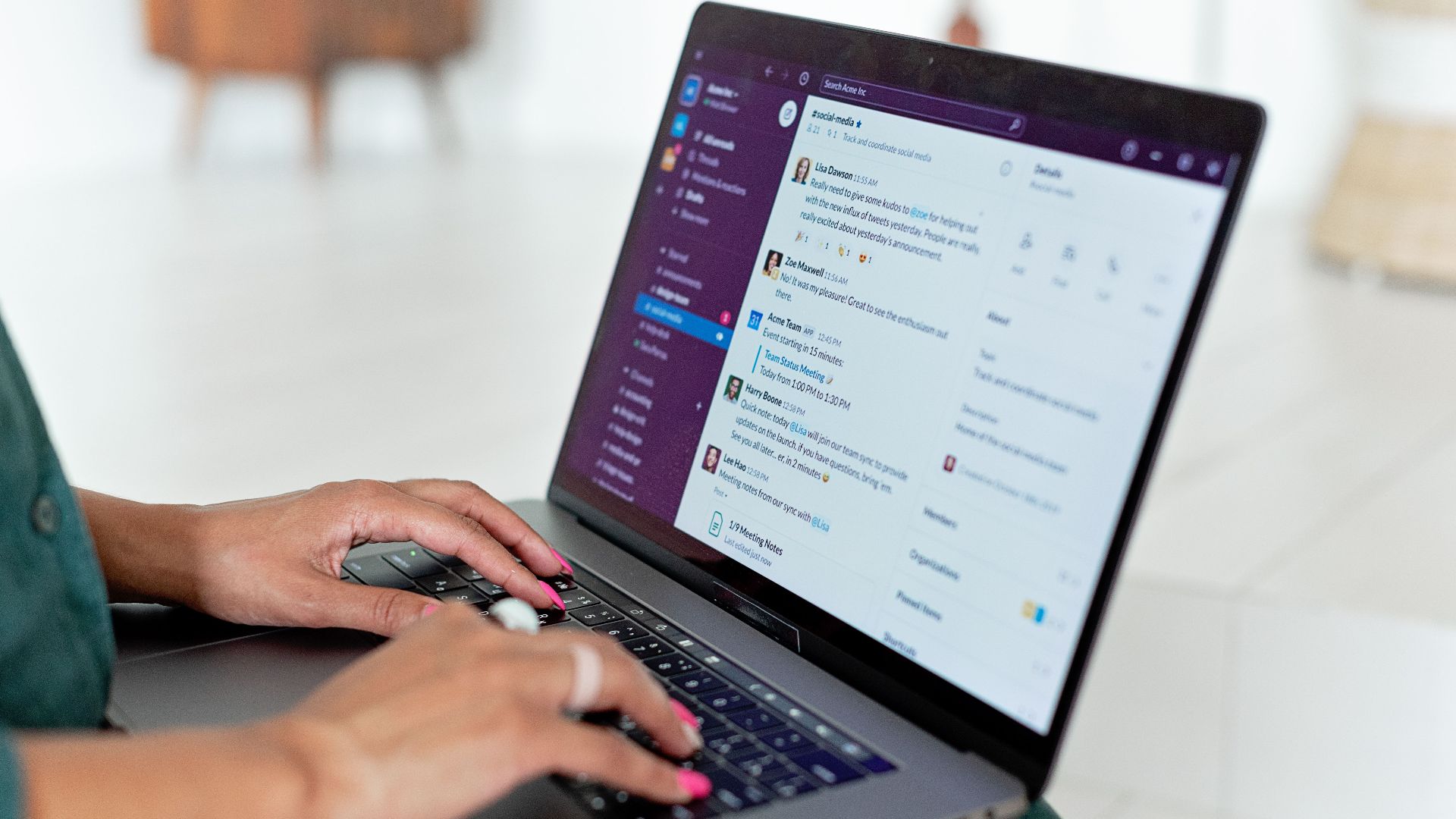 Woman typing on a laptop using a messaging app in a home setting, close-up of hands.