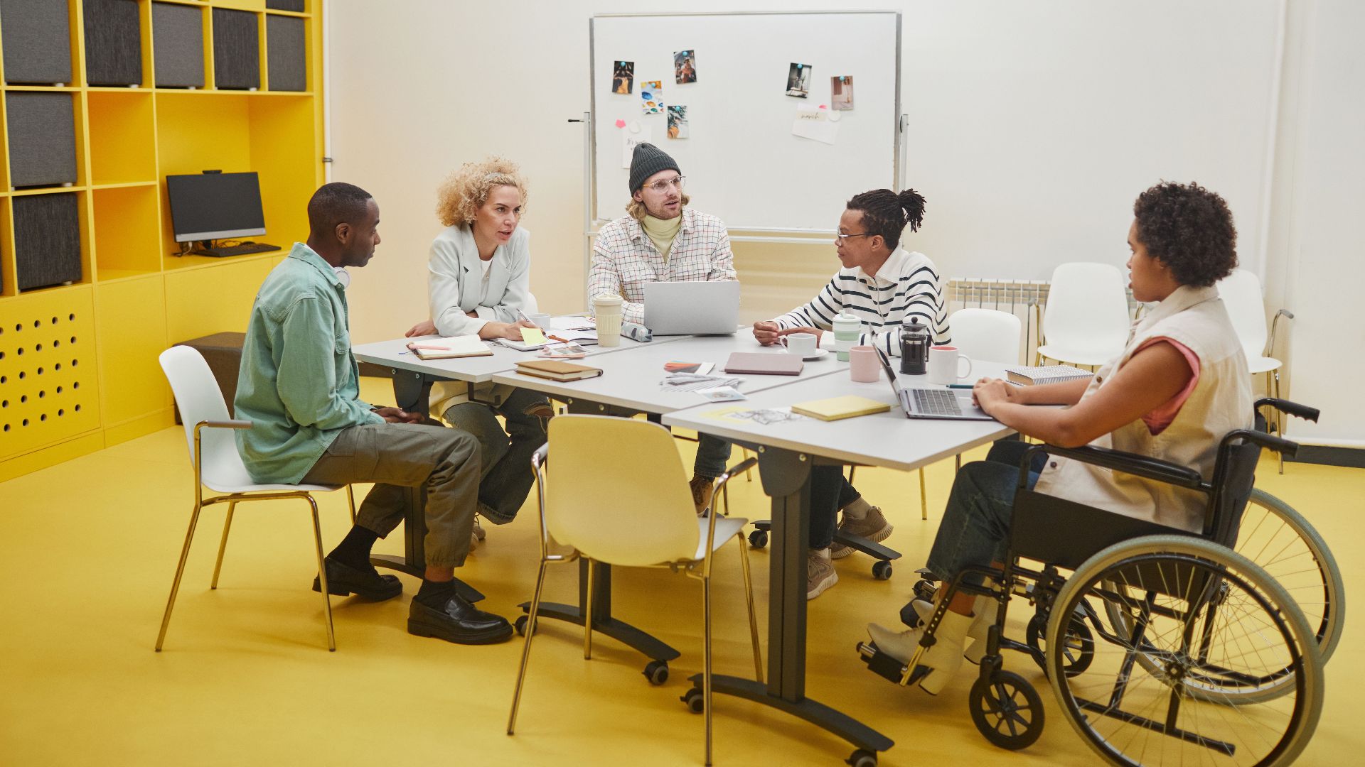 A diverse group of coworkers having a collaborative meeting around a table in a modern office.