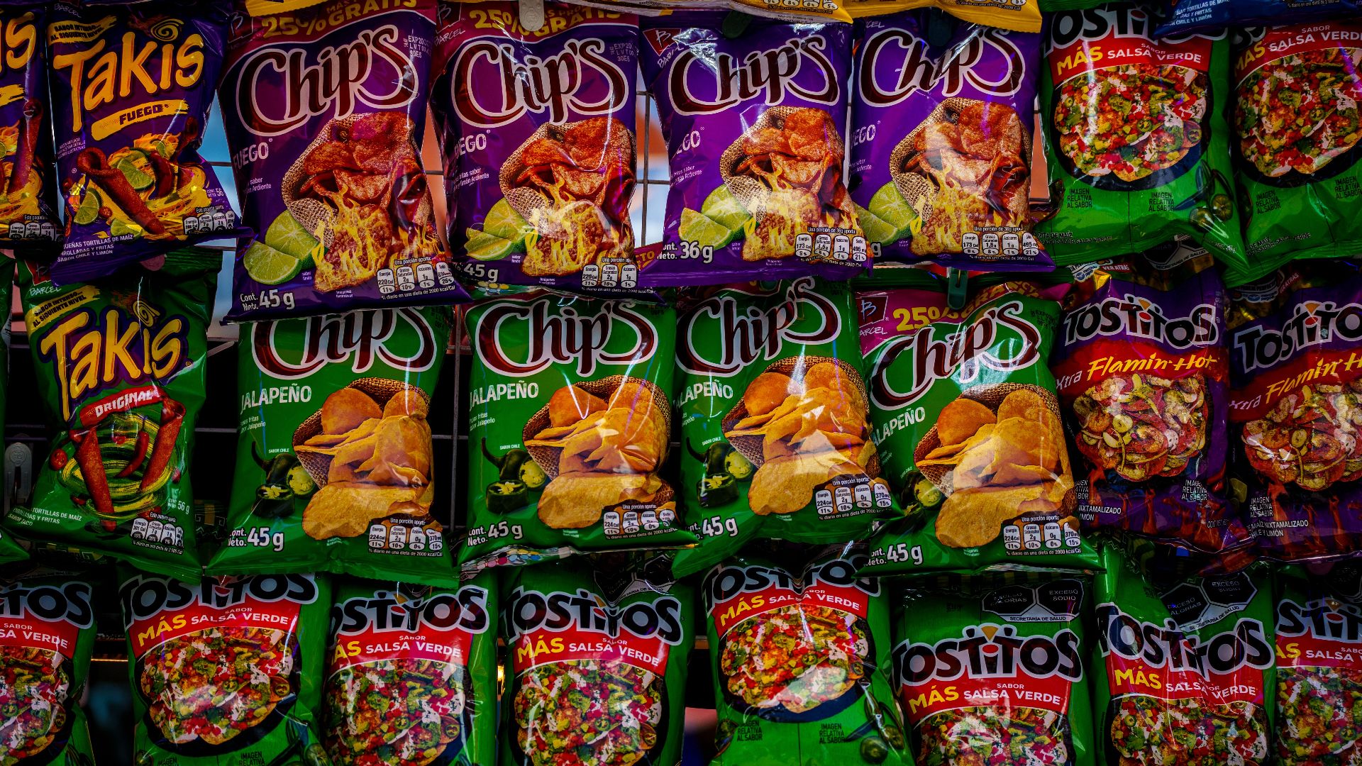 Colorful assortment of snack bags displayed on a shelf, showcasing popular brands and flavors.