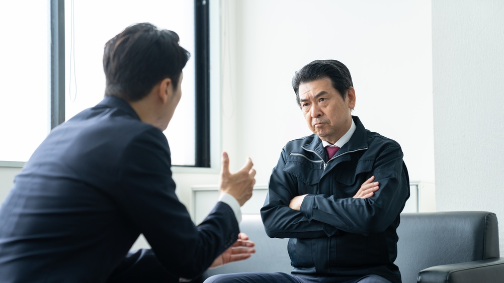 Middle-aged businessmen receiving sales pitches in their offices