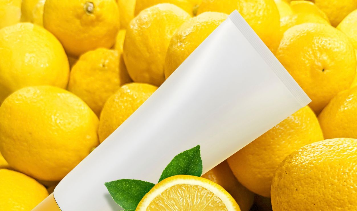 Natural vitamin c skincare products fresh juicy lemon fruit slice and green leaf on lemon background. Cosmetic beauty product branding mock-up for moisturizing cream, lotion, foam or shampoo