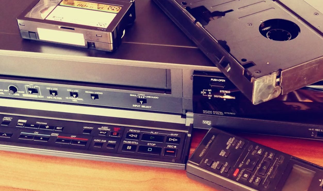 Vintage VHS player with cassette and remote control, representing classic tech nostalgia