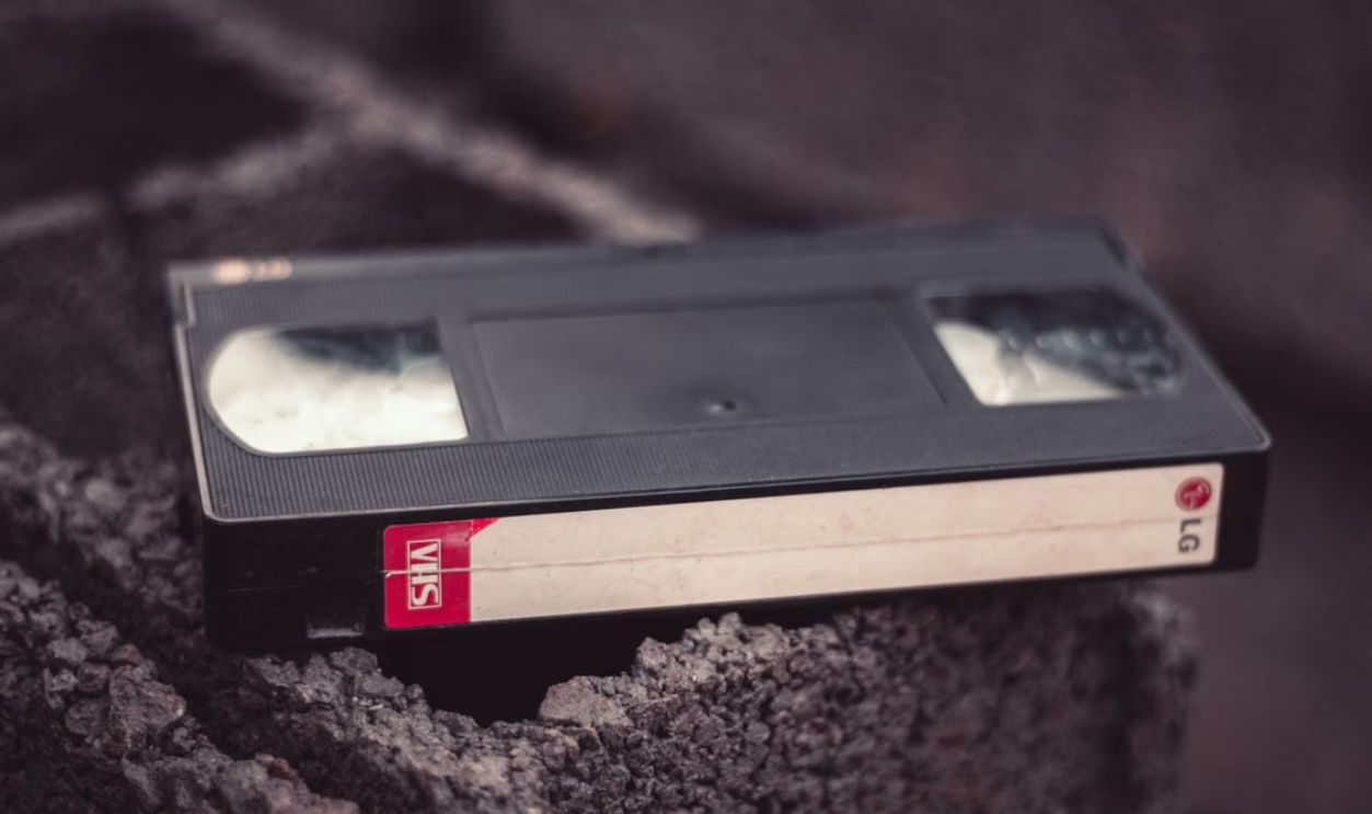 Close-up of a vintage VHS tape resting on a textured surface, offering nostalgic appeal