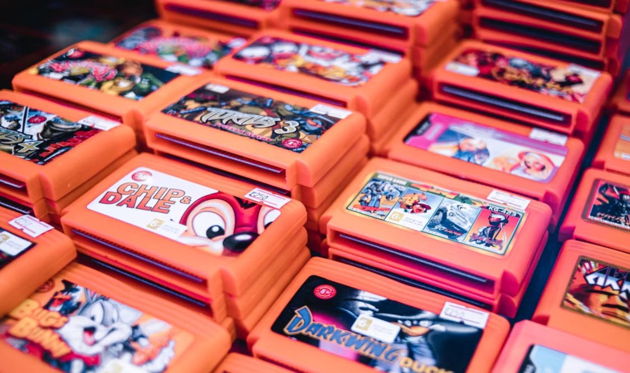 Close-up of stacked retro video game cartridges in orange cases, showcasing popular titles
