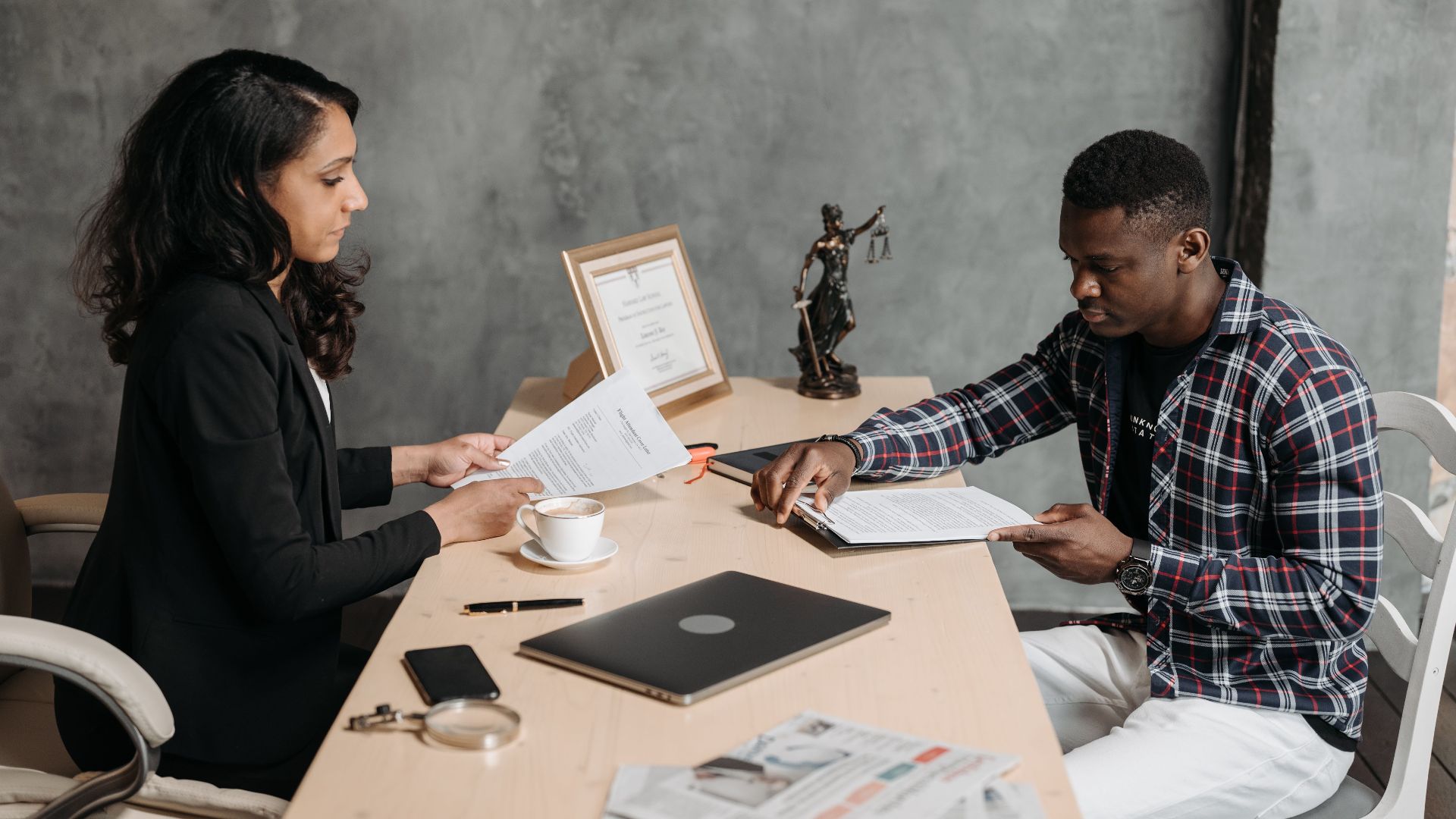 Business professionals discussing documents in a modern office setting.