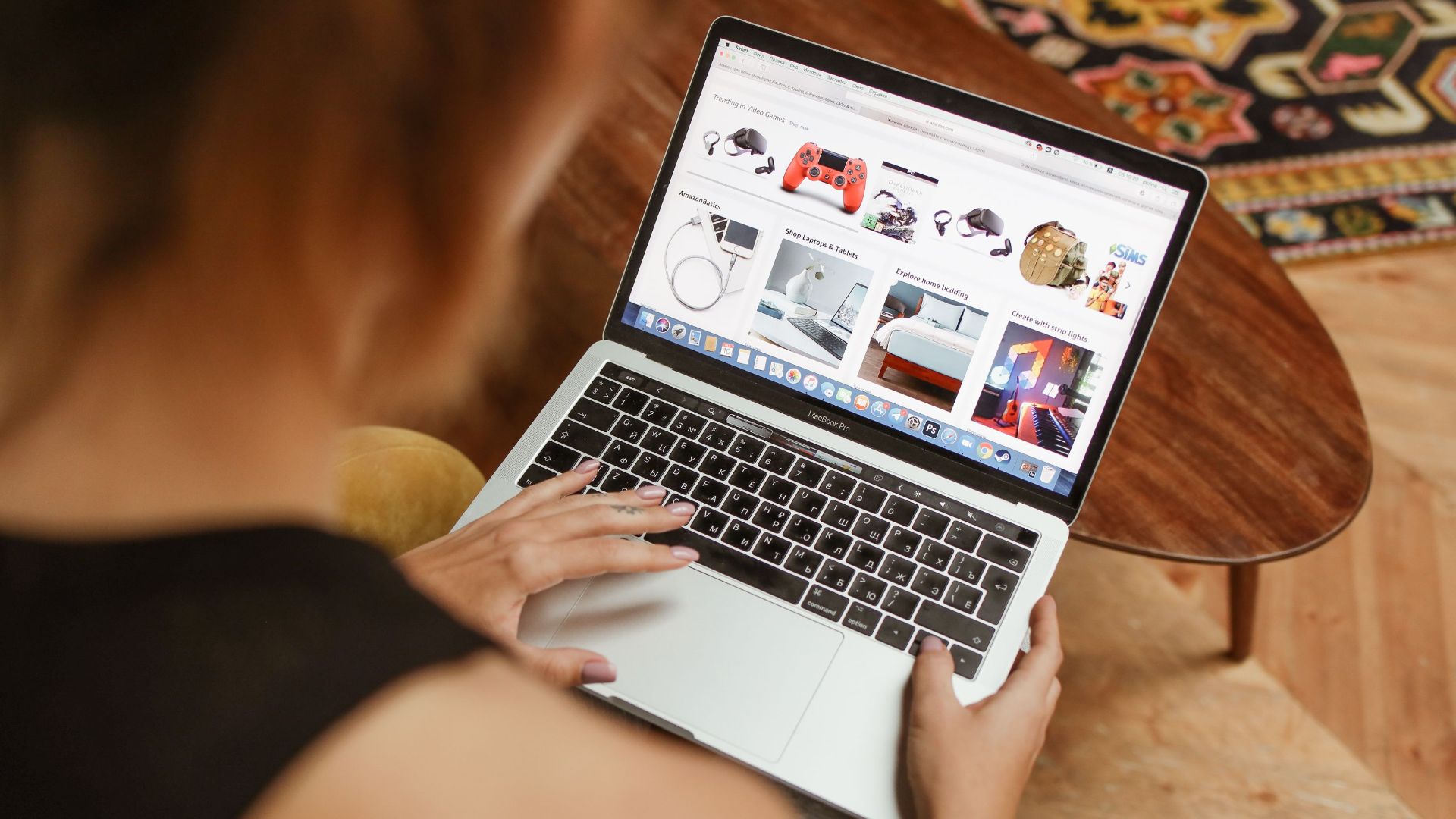 A woman shops online on her laptop while seated in a cozy home environment.