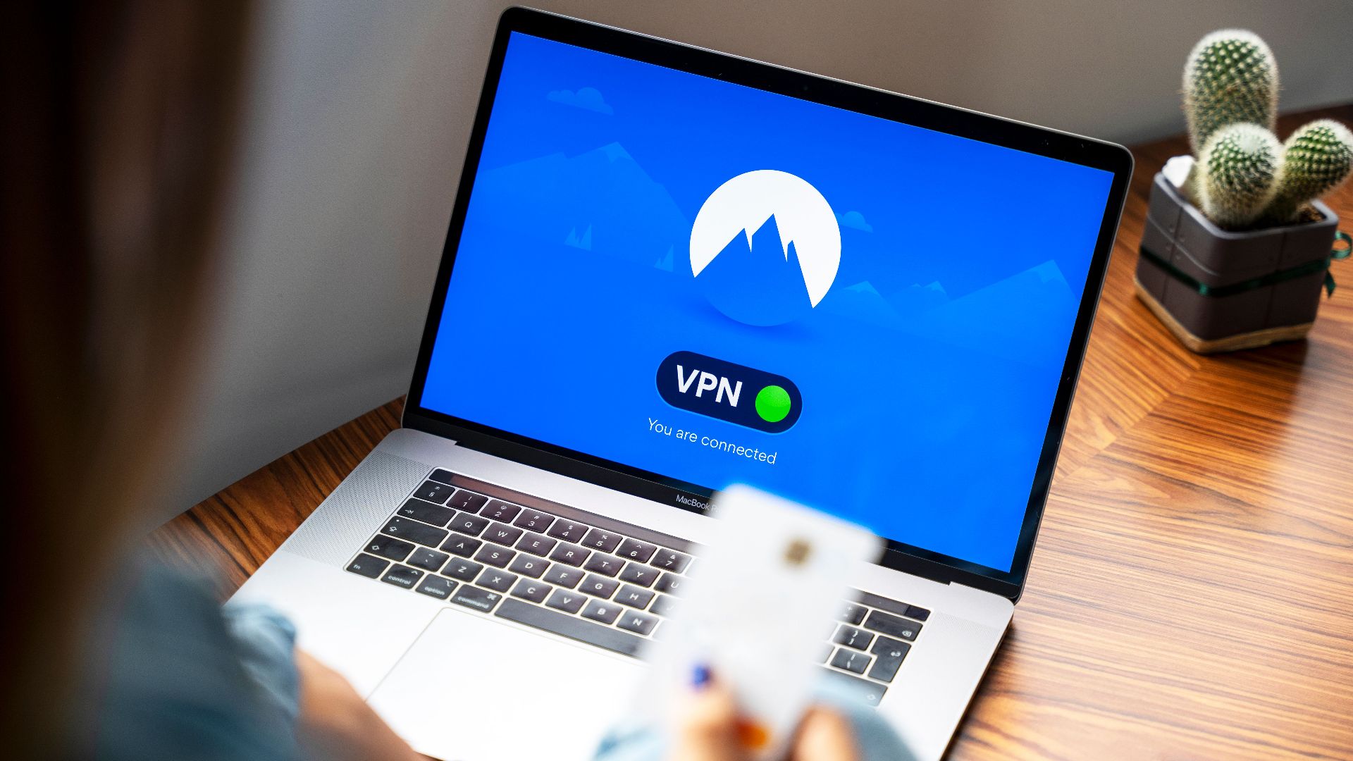 A person using a VPN on a laptop, symbolizing secure internet browsing in a modern indoor setting.