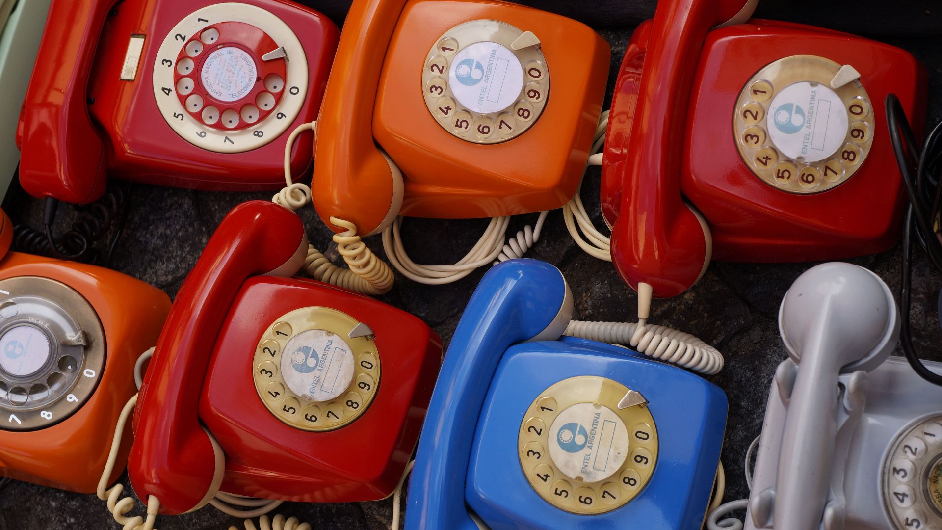 A collection of colorful vintage rotary telephones evokes nostalgic charm and retro style.