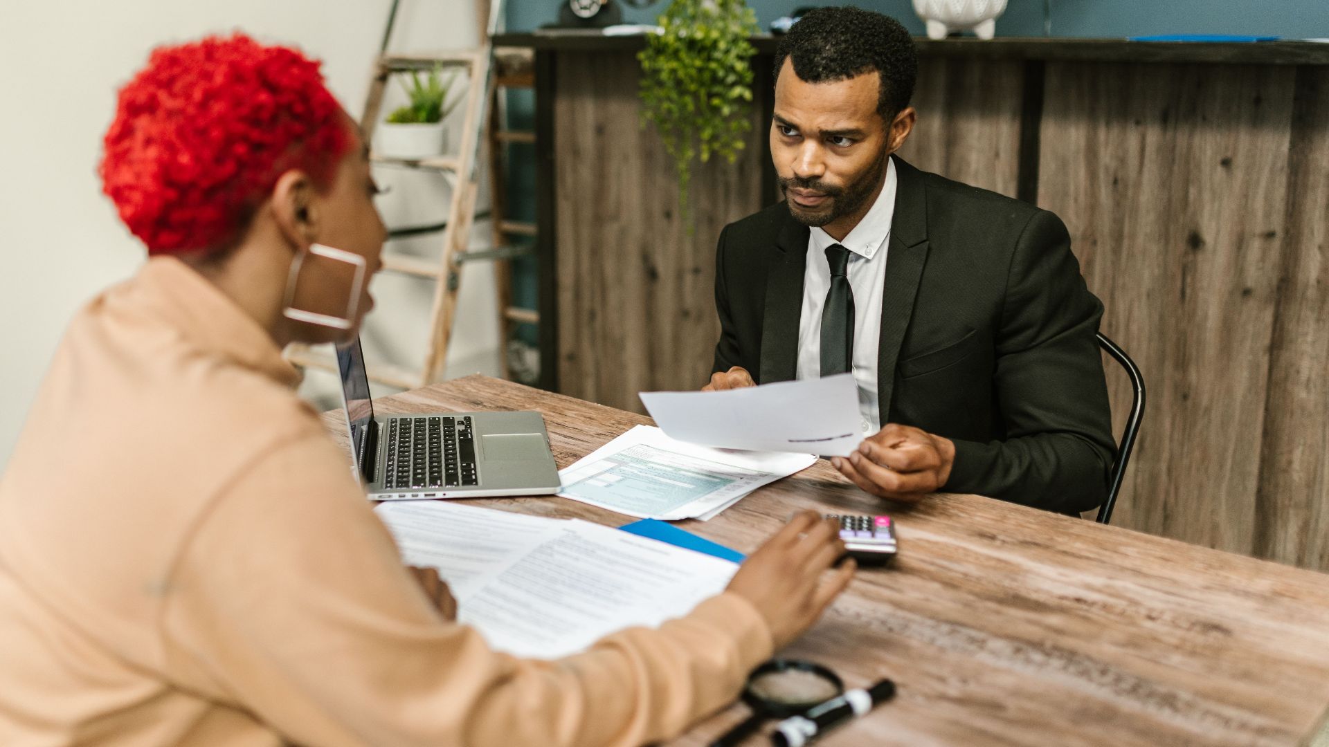 A discussion between two professionals focusing on financial documents in a modern office setting.