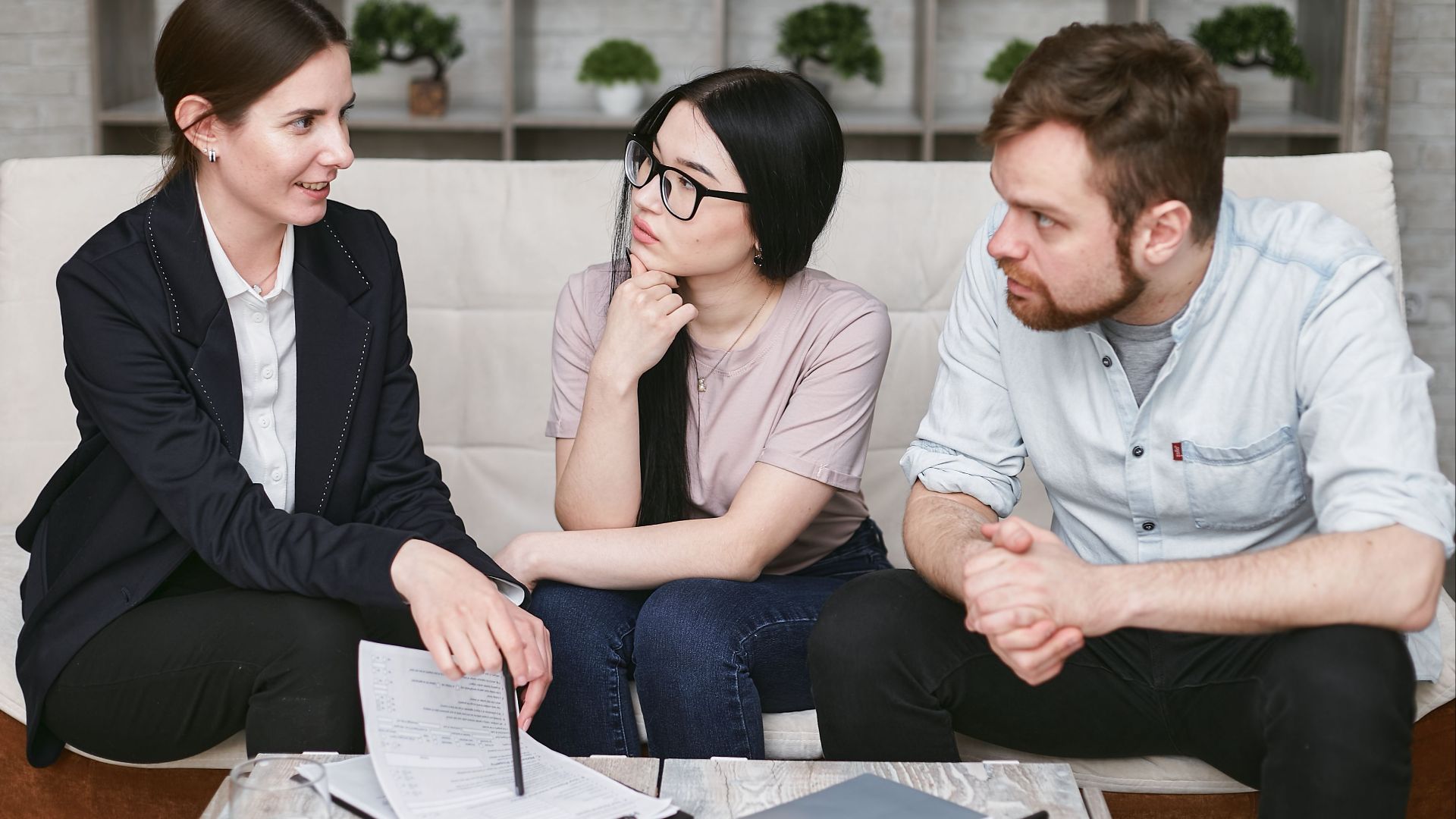 Three adults discussing business inside, focused on cooperation and strategy.