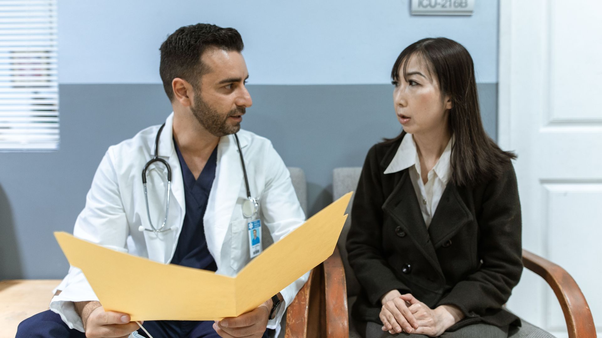 Healthcare professional consults patient in clinical setting. Medical discussion and diagnosis.