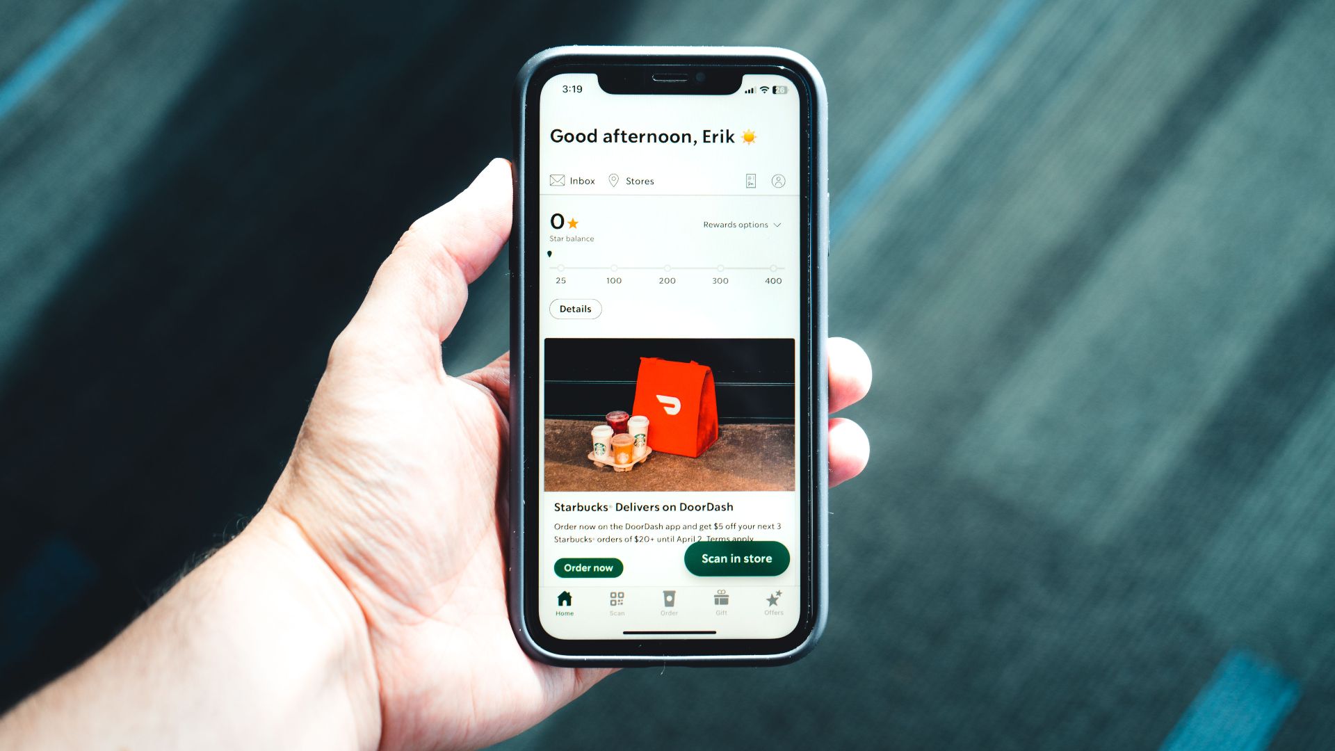 Close-up of a smartphone with a delivery app interface in a person's hand, emphasizing modern e-commerce.