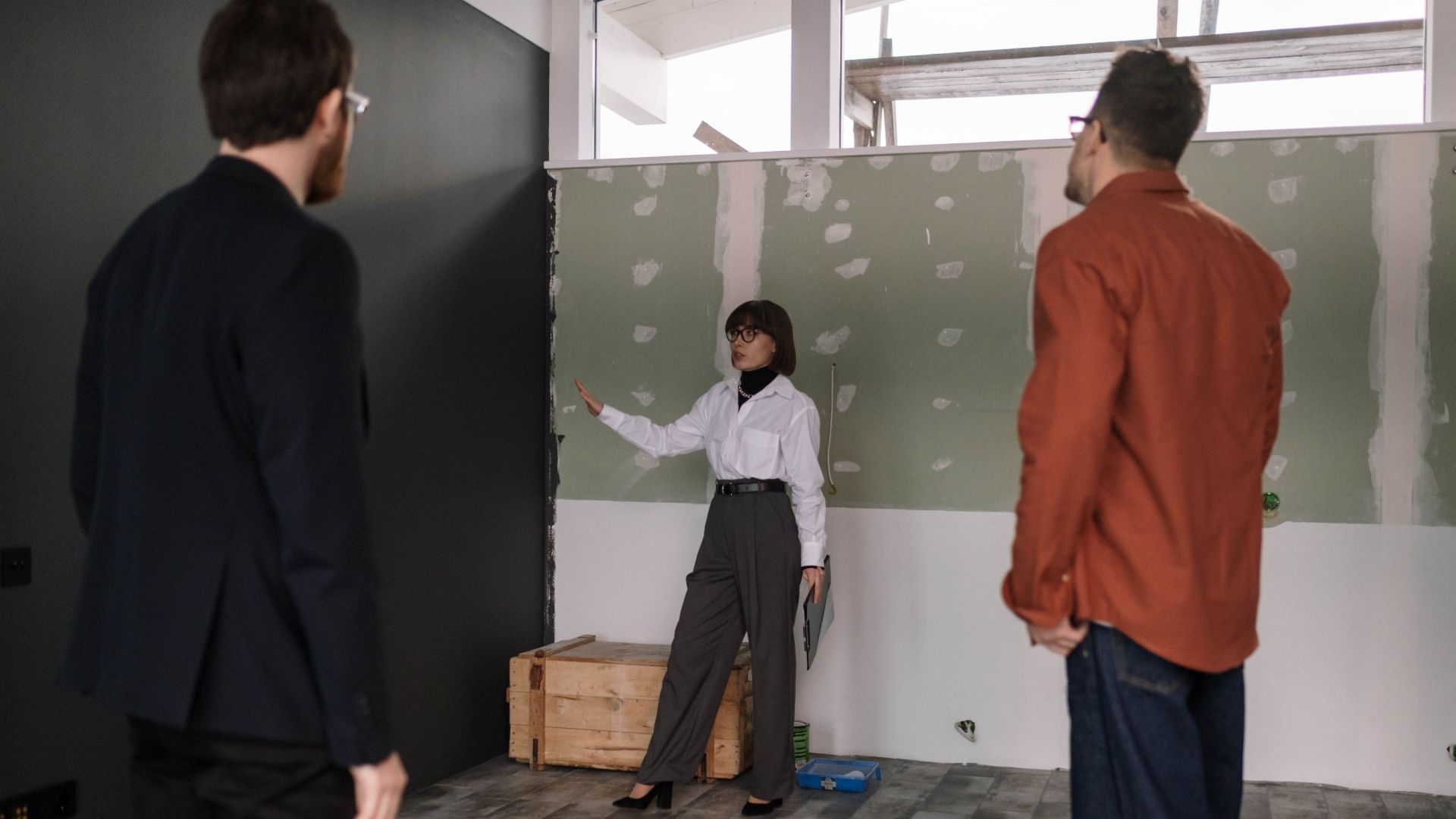 A group of professionals discussing a renovation project inside a building.