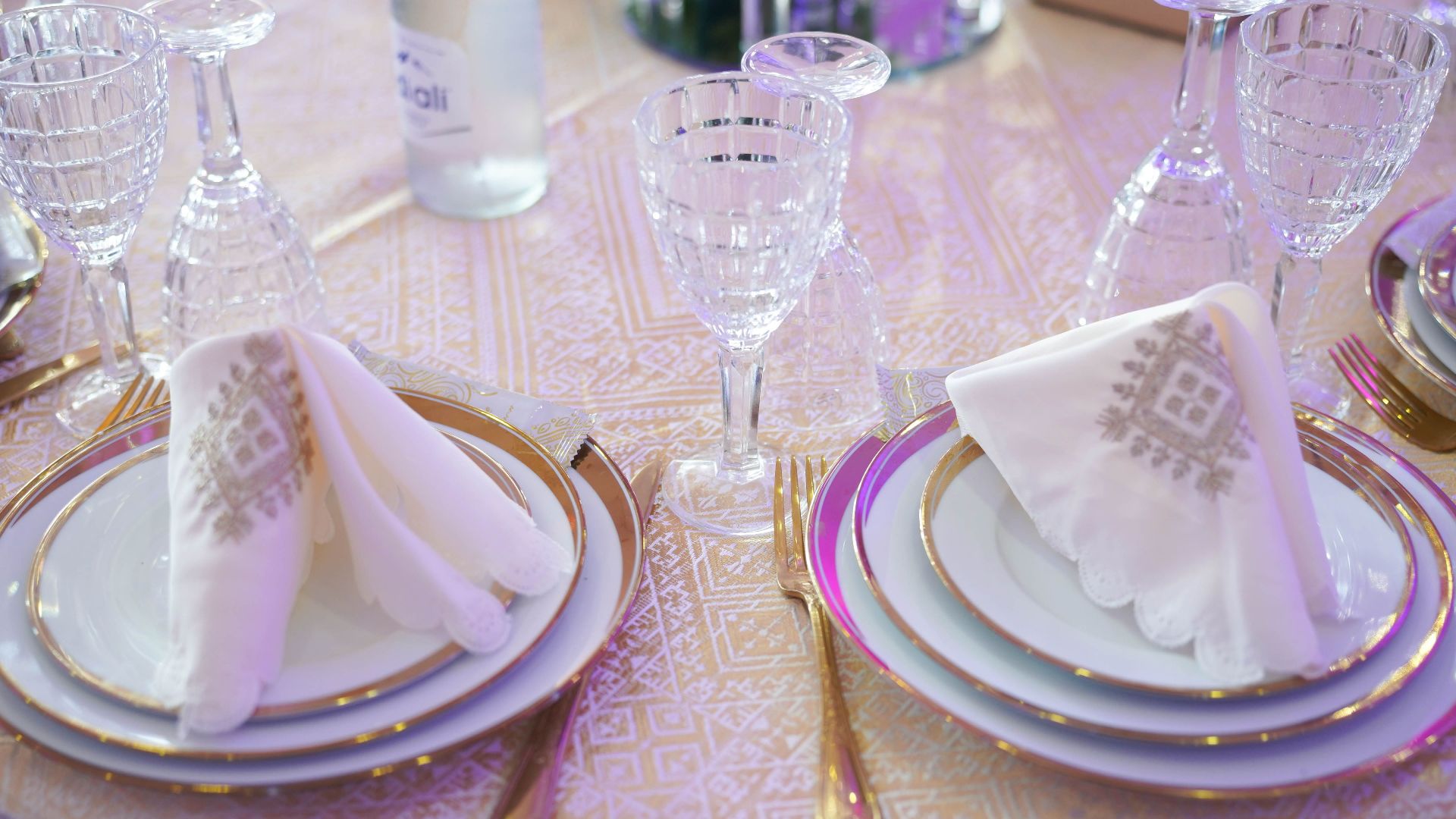 Beautifully arranged formal table setting with crystal glassware and ornate napkins, ideal for weddings or special occasions.