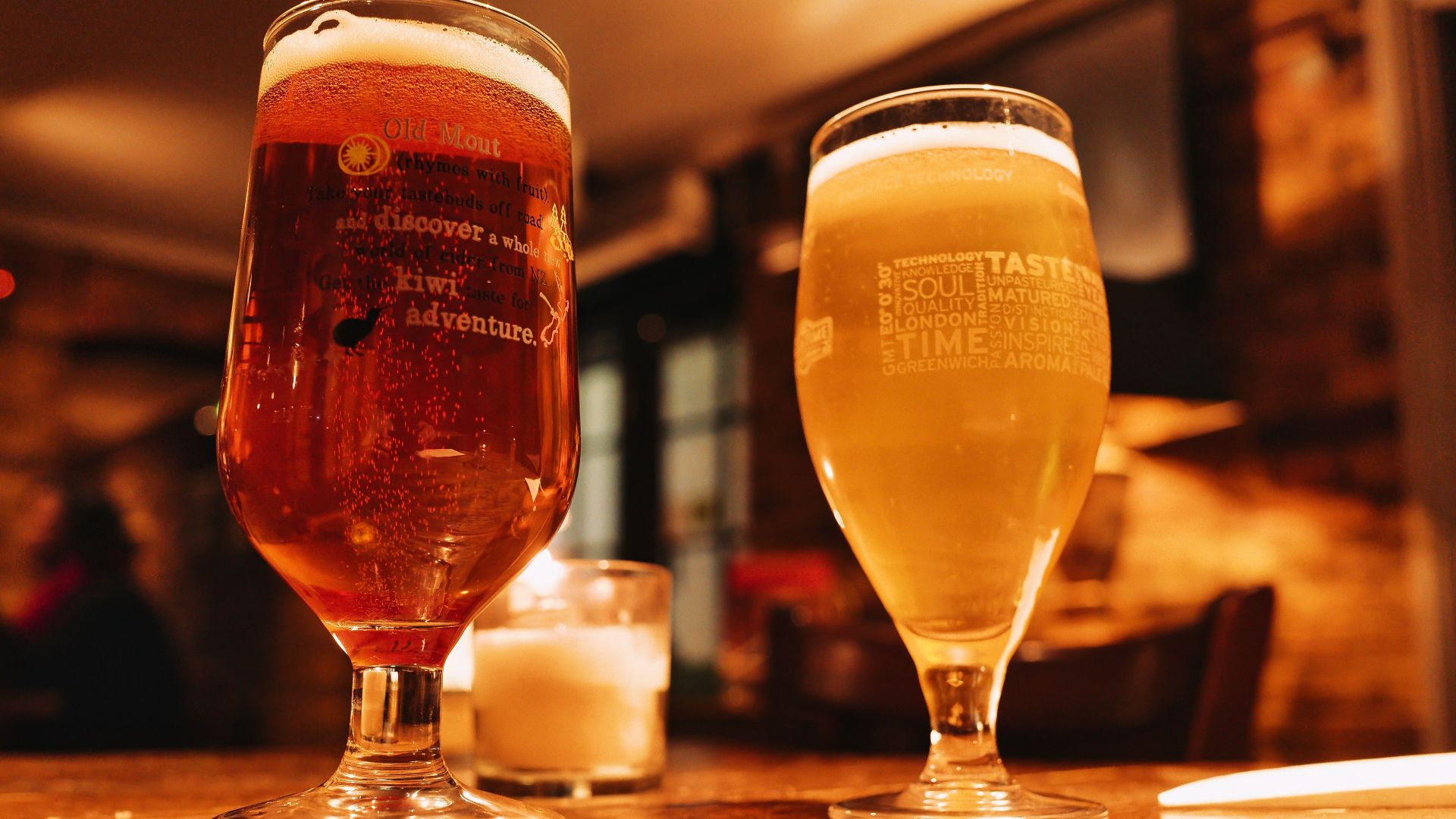 Warm and inviting pub setting with two beers on a wooden table.