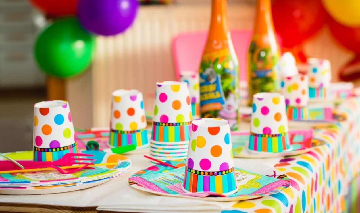 Colorful party table setup with polka dot cups and balloons, perfect for celebrations