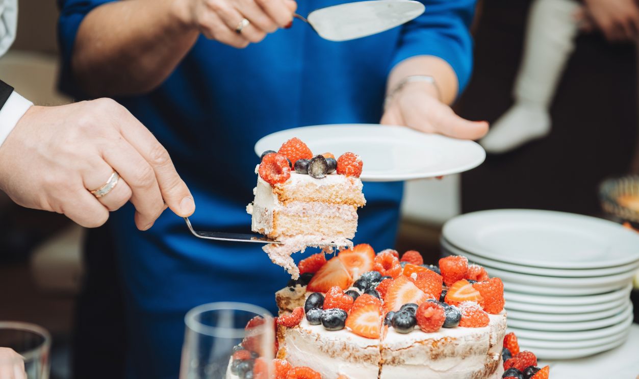 Festive cake with white cream, decorated with raspberries and strawberries