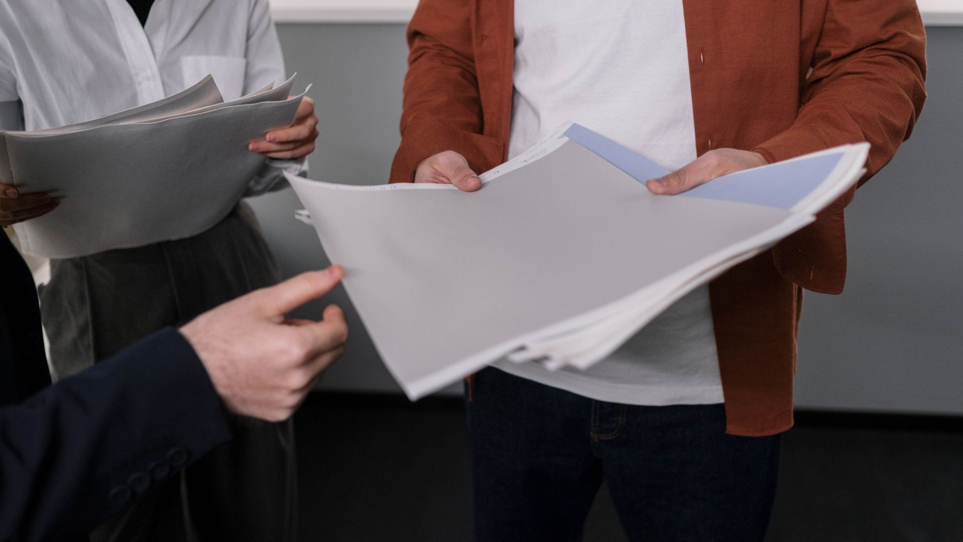 Business professionals discussing interior design samples during a project meeting.