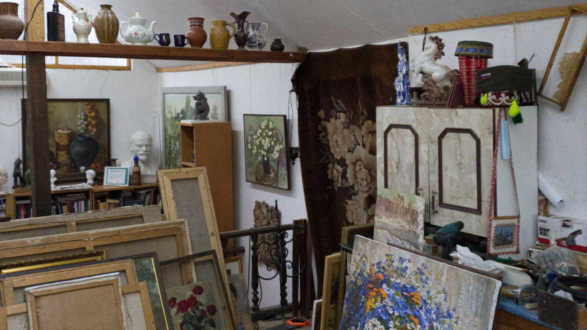 A charming attic space filled with vintage paintings, furniture, and antiques.