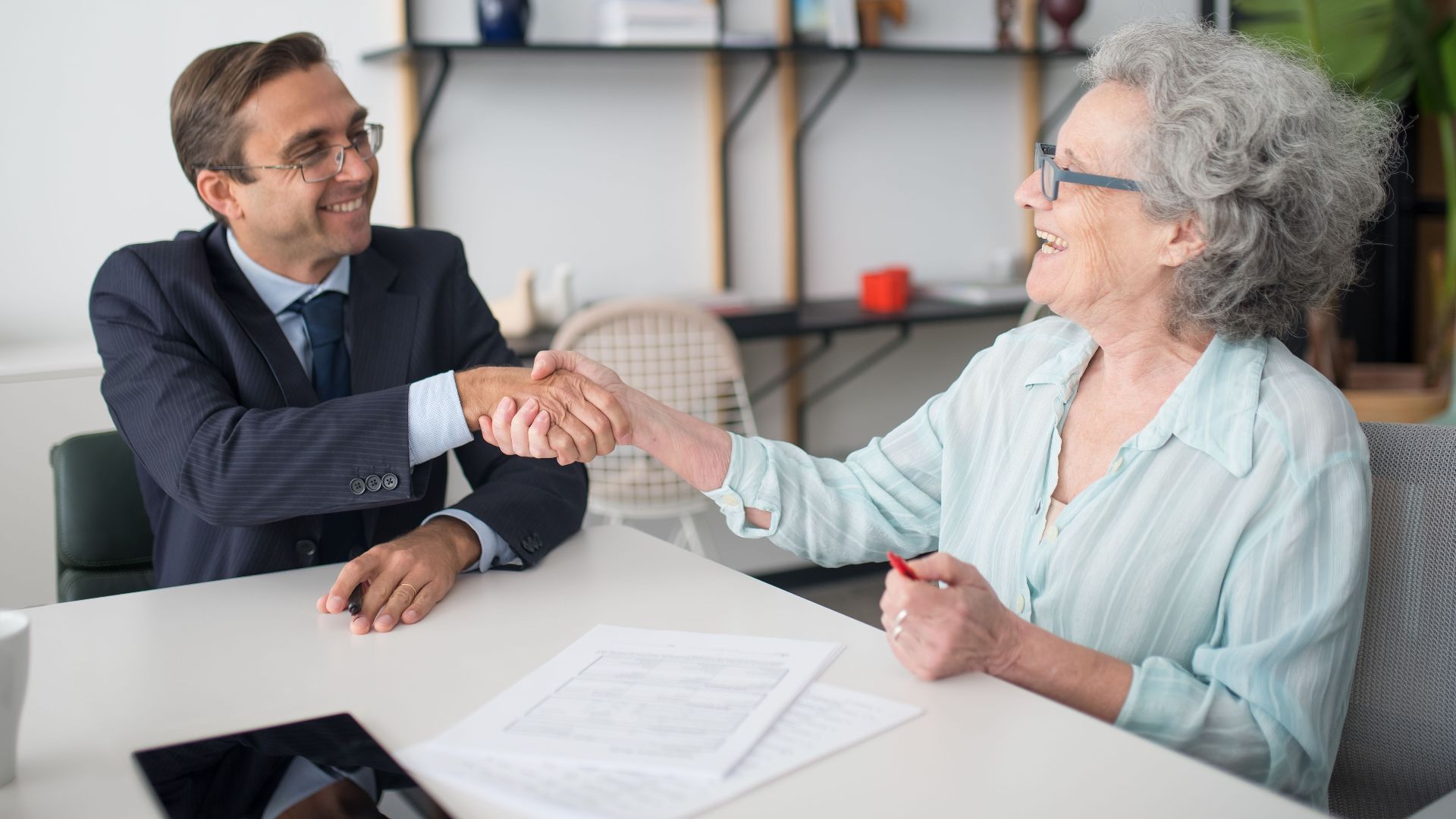 Professional business meeting with a handshake between consultant and client at an office.