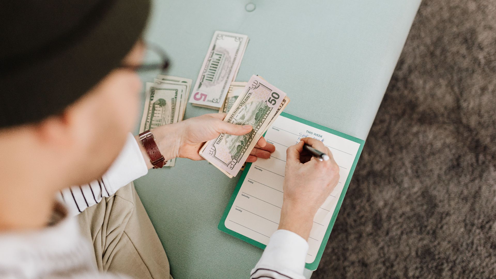 Individual budgeting with US dollars and a planner, focusing on financial planning.