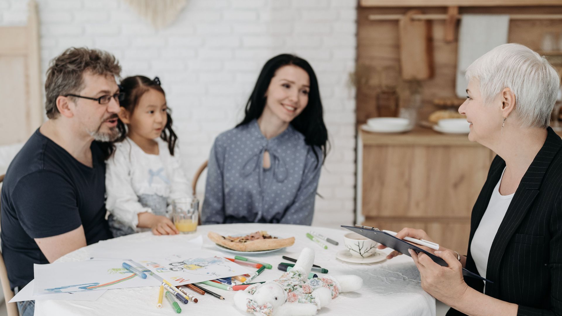 Adoptive family discussing with a social worker indoors, creating a warm, welcoming atmosphere.