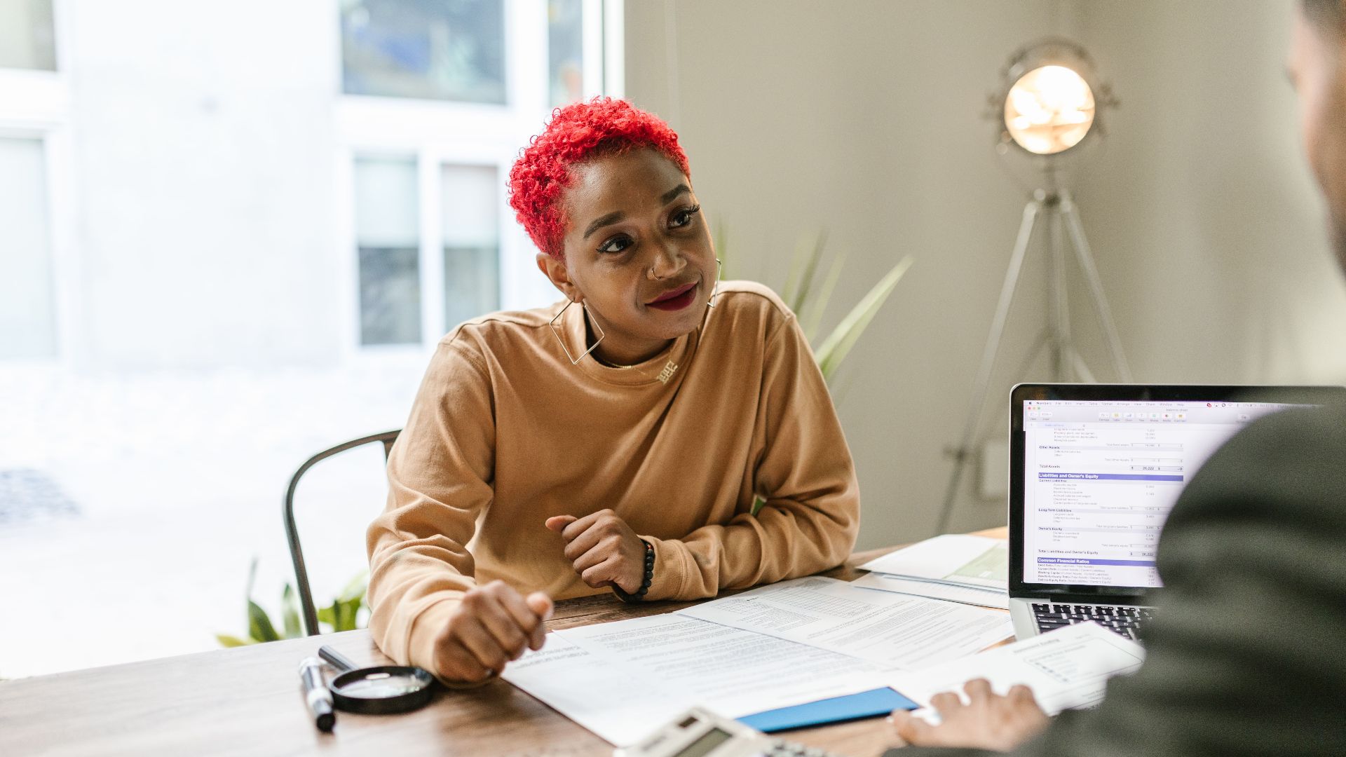 Professional woman engaged in thoughtful discussion at a business meeting indoors.