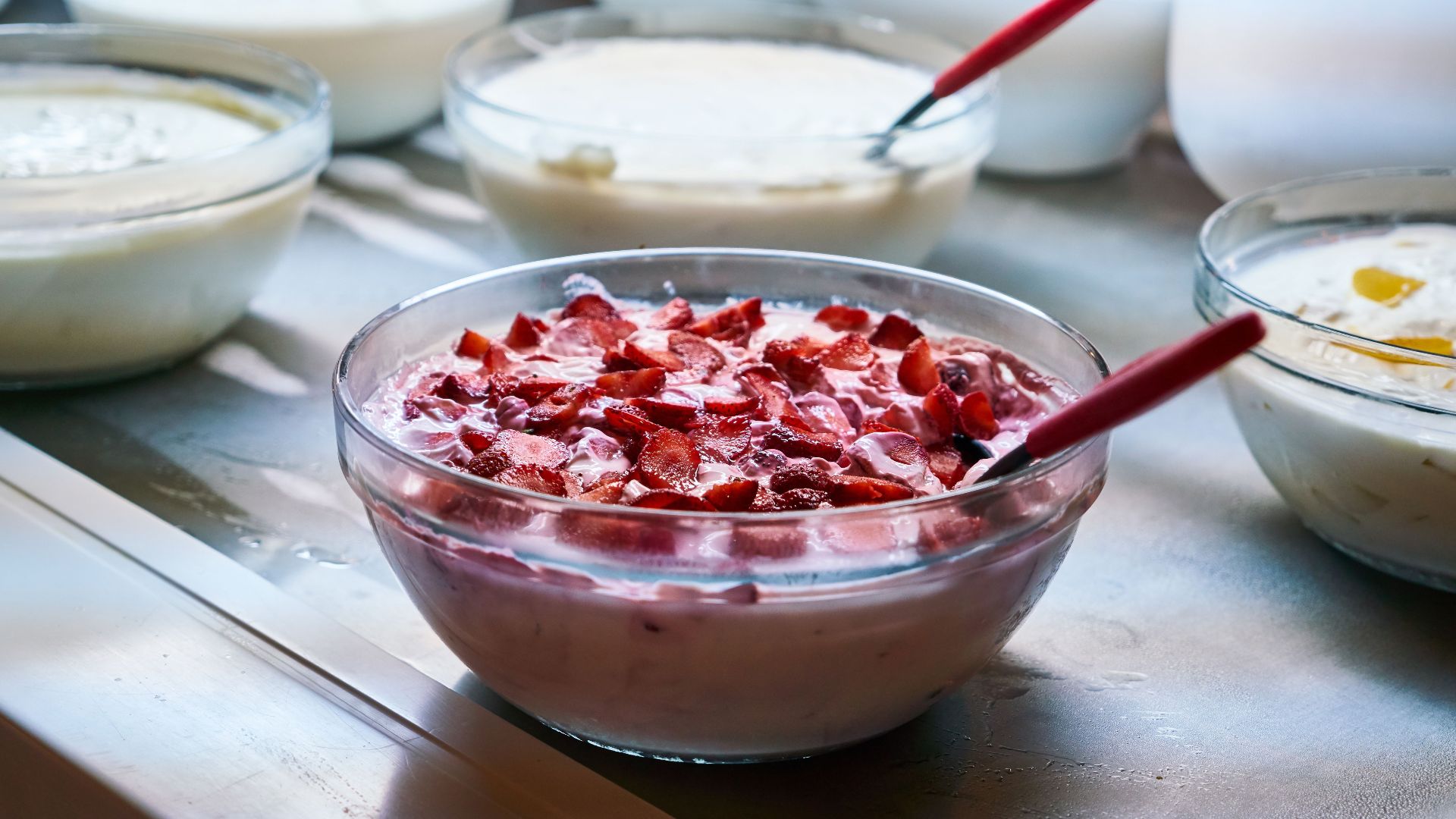 A variety of homemade yogurt dishes with fresh fruit toppings in bowls, perfect for breakfast or a healthy snack.