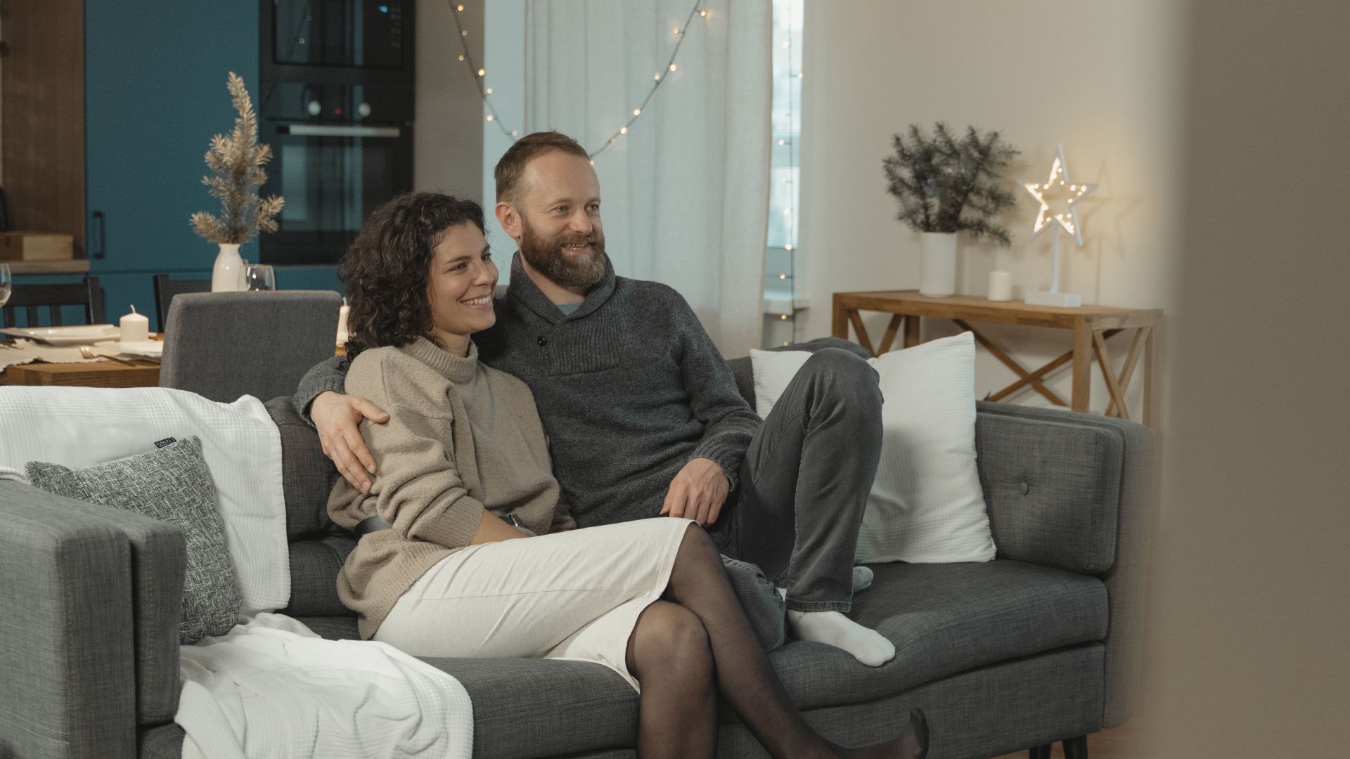 Couple sitting together in a cozy, modern living room, enjoying a relaxing day indoors.