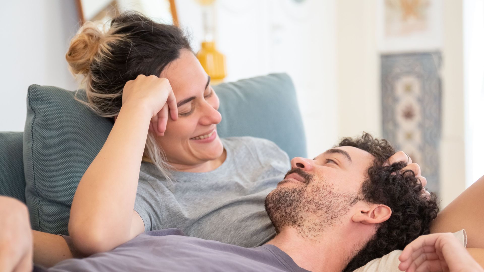 A loving couple enjoys a relaxed moment at home, showcasing affection and comfort.