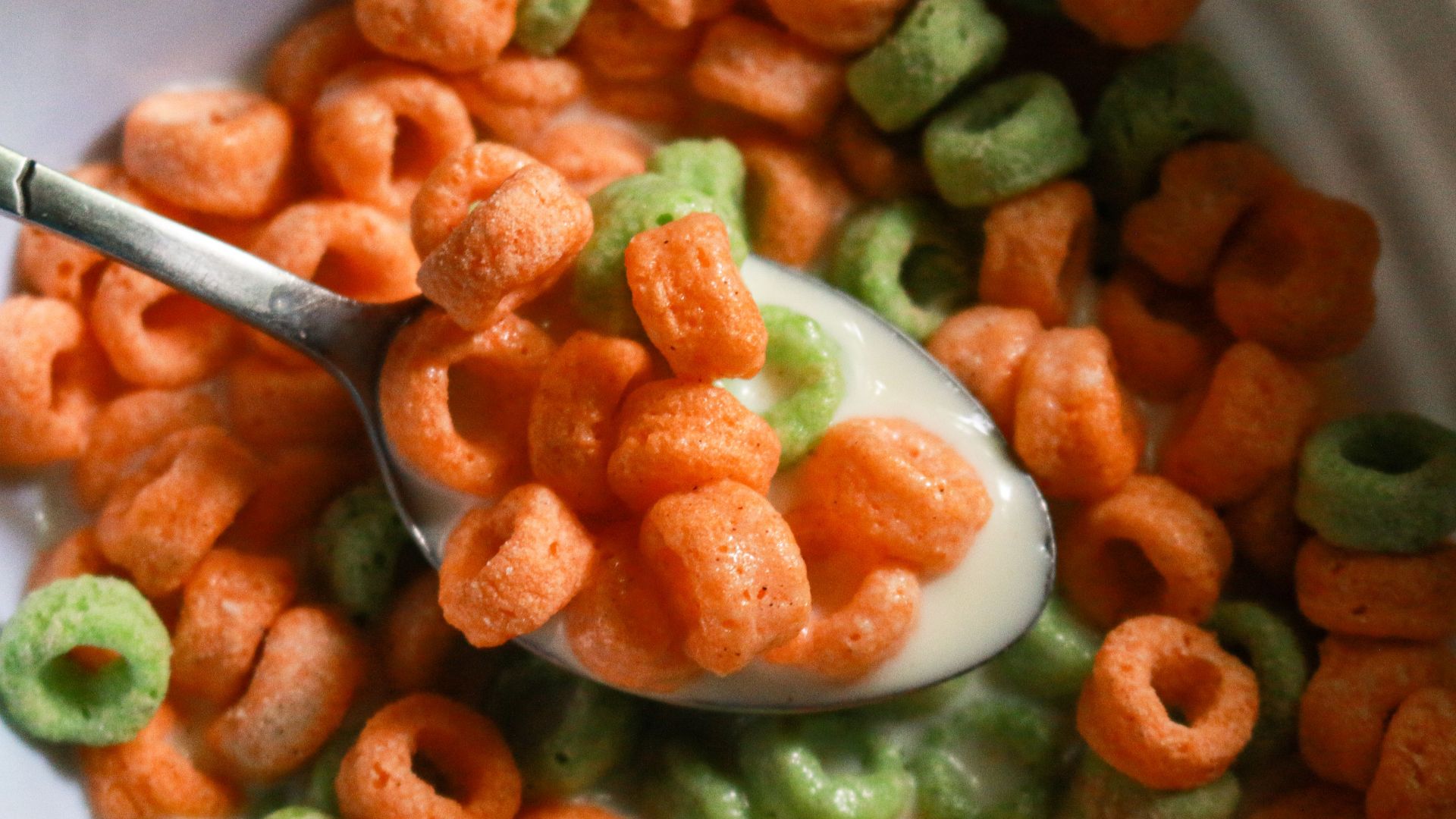 A close-up view of colorful cereal rings in milk, ready for a delicious breakfast.