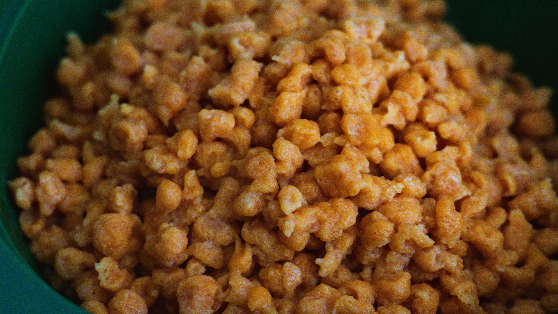 Close-up of honey coated cereal in a green bowl, perfect for breakfast.