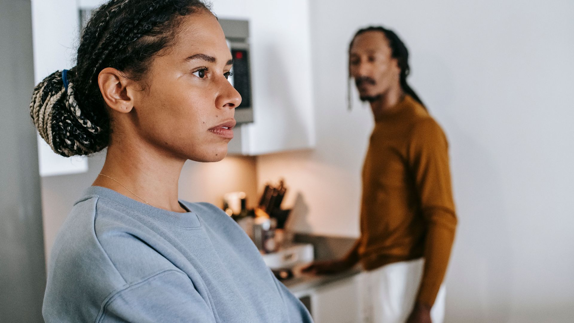 Black lady and guy standing in kitchen at home and having conflict while arguing
